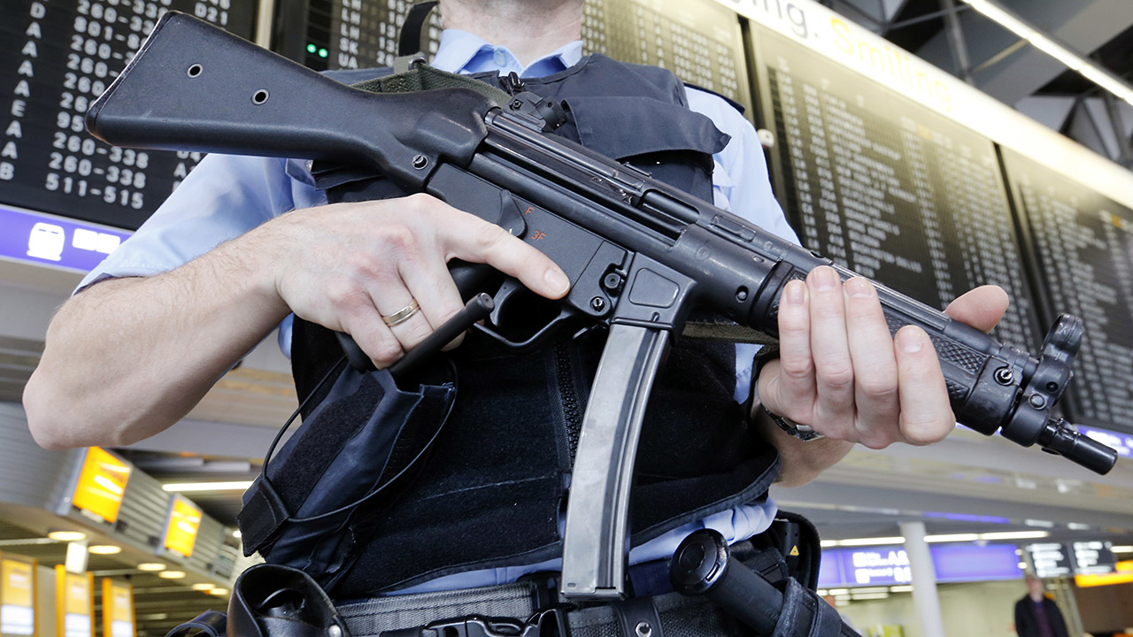 Ein bewaffneter Polizist sichert ein Flughafenterminal 