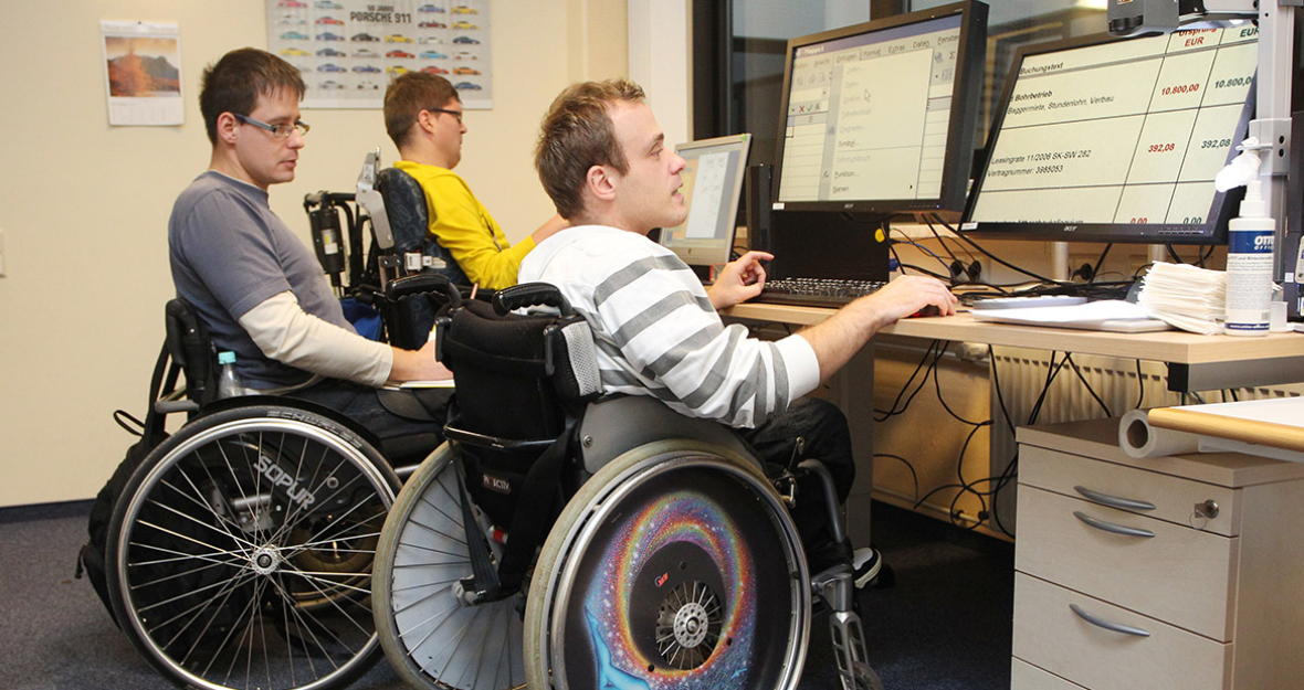 Mitarbeiter einer Behindertenwerkstatt arbeiten am PC Mitarbeiter einer Behindertenwerkstatt arbeiten am PC