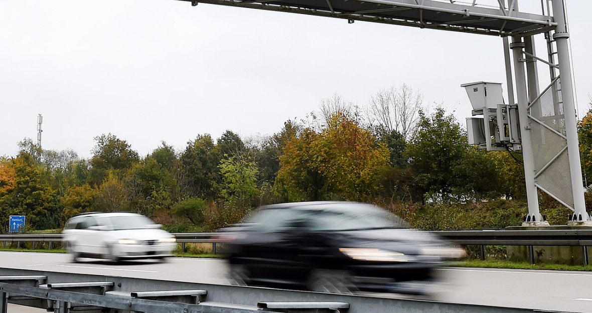 Autos fahren unter einer Mautbrücke