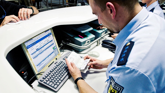 Bundespolizist überprüft einen Ausweis