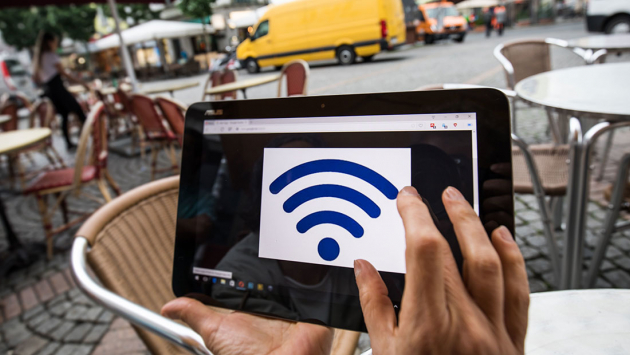 W-LAN Logo wird in einem Cafe auf dem Bildschirm eines Tablet-Computers angezeigt