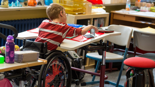 Schulkind im Rollstuhl nimmt am Unterricht teil.