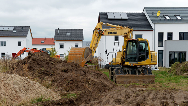 Bagger auf einer Baustelle in einem Neubaugebiet Bagger auf einer Baustelle in einem Neubaugebiet