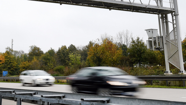 Autos fahren unter einer Mautbrücke Autos fahren unter einer Mautbrücke
