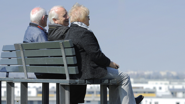 Drei Rentner sitzen auf einer Bank