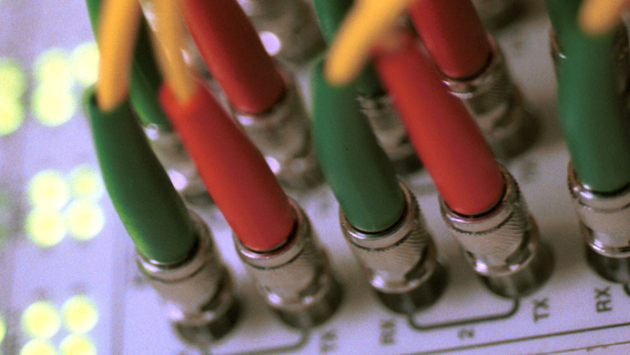 Blick auf zentralen Verteiler-Knoten eines IT-Netzwerkes im Ethernet-Standard mit Kabeln und Kontrolllampen Blick auf zentralen Verteiler-Knoten eines IT-Netzwerkes im Ethernet-Standard mit Kabeln und Kontrolllampen