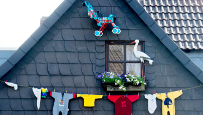 Babystrampler hängen an einem Einfamilienhaus