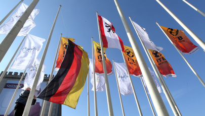 Ein Mitarbeiter der Messe Berlin zieht vor dem Hauptgebäude der Messehallen in Berlin Flaggen der Ausstellerländer hoch.