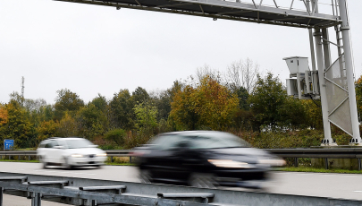 Autos fahren unter einer Mautbrücke