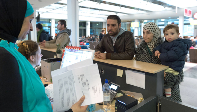 Eine Sprachermittlerin hilft in der Registrierungsstelle für Flüchtlinge einer Familie aus Syrien