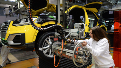 Fertigungsmechanikerin arbeitet an einem Fließband im Audi-Werk Ingolstadt